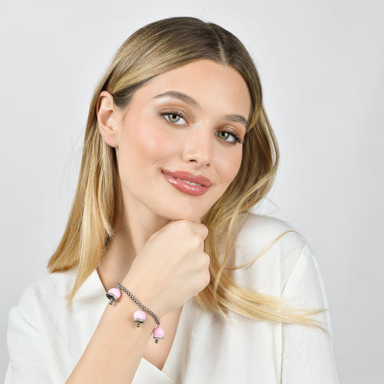 DAMENARMBAND AUS STAHL MIT ROSA EMAILLE-GLOCKEN UND WEISSEN KRISTALLEN